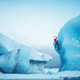 A North Face team climber hanging on the edge of an icy ledge